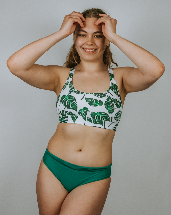 Frau in bekeen Bikinihose grün "alga" und bekeen Bikinitop Monstera "jungle" am Wasserfall