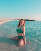 Frau in bekeen Bikini grün "alga" am Strand