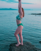 Frau in bekeen Bikini grüne Hose "alga" und Bikini Top mit Monstera Muster "jungle"